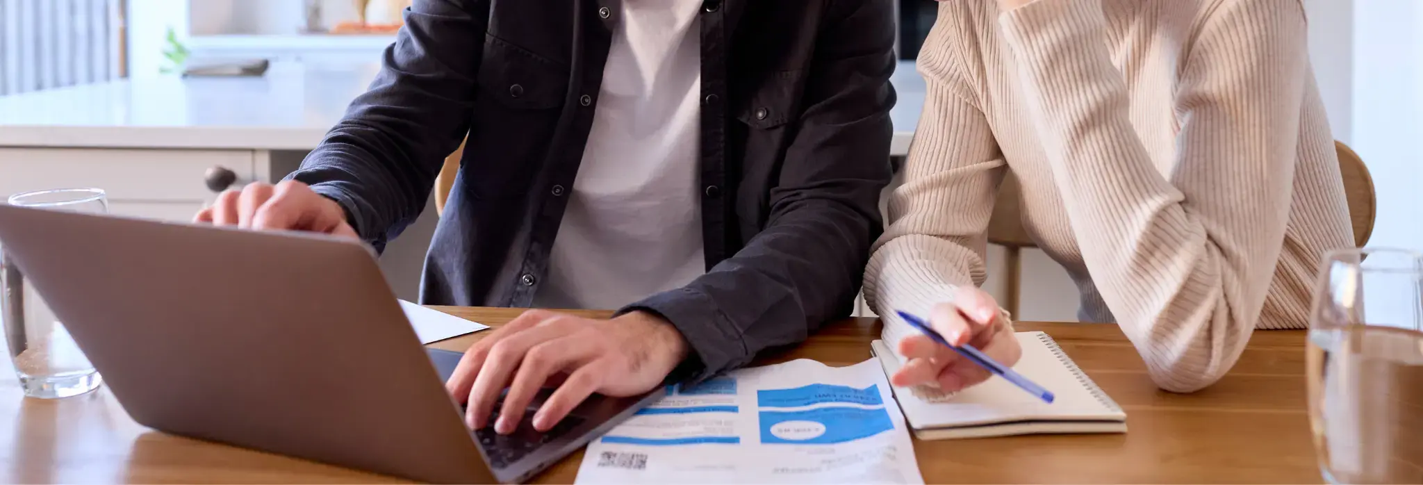 Δύο άνθρωποι σε γραφείο με φορητό υπολογιστή και λογαριασμό ρεύματος.