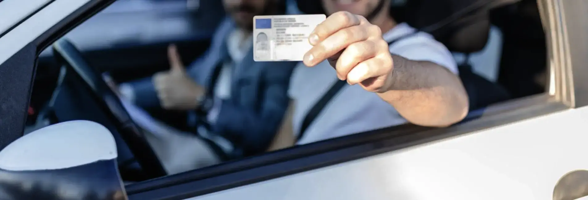 Νέος οδηγός δείχνει το δίπλωμα οδήγησης αυτοκινήτου.