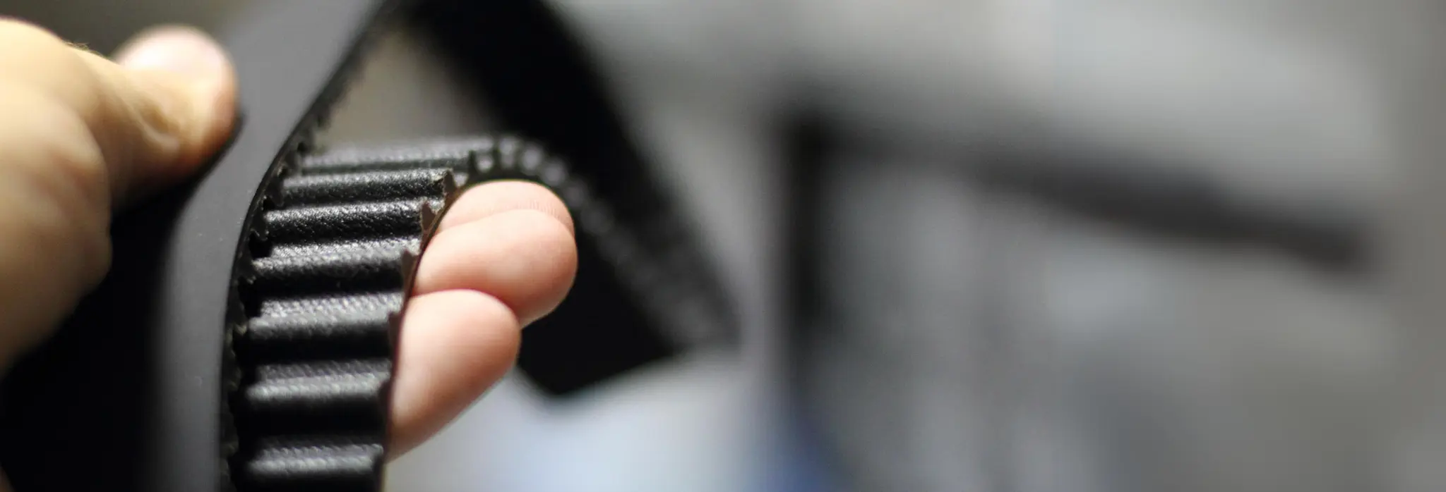 Χέρι που κρατάει ιμάντα χρονισμού.