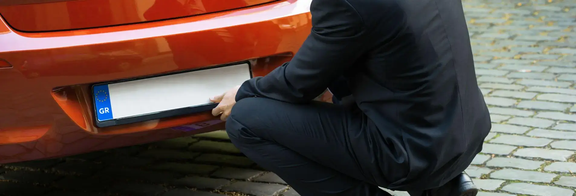 Άντρας αφαιρεί τις πινακίδες από το αυτοκίνητο  του για προσωρινή κατάθεση.