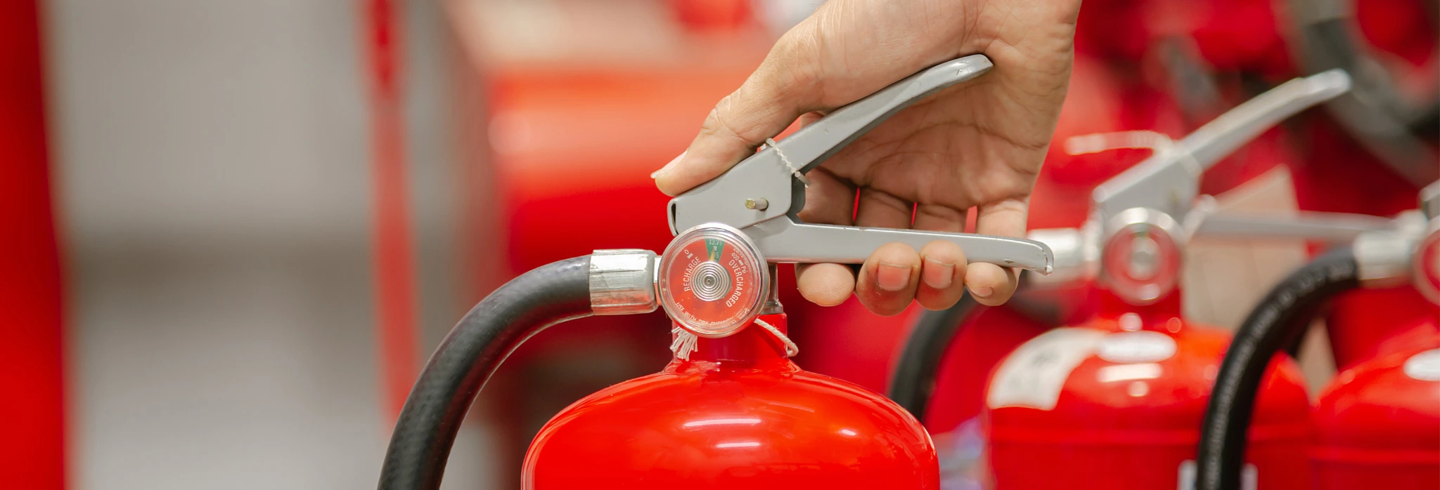 Χέρι κρατάει πυροσβεστήρα.