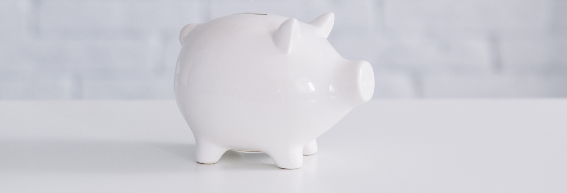 Λευκός κουμπαράς σε σχήμα γουρουνάκι.