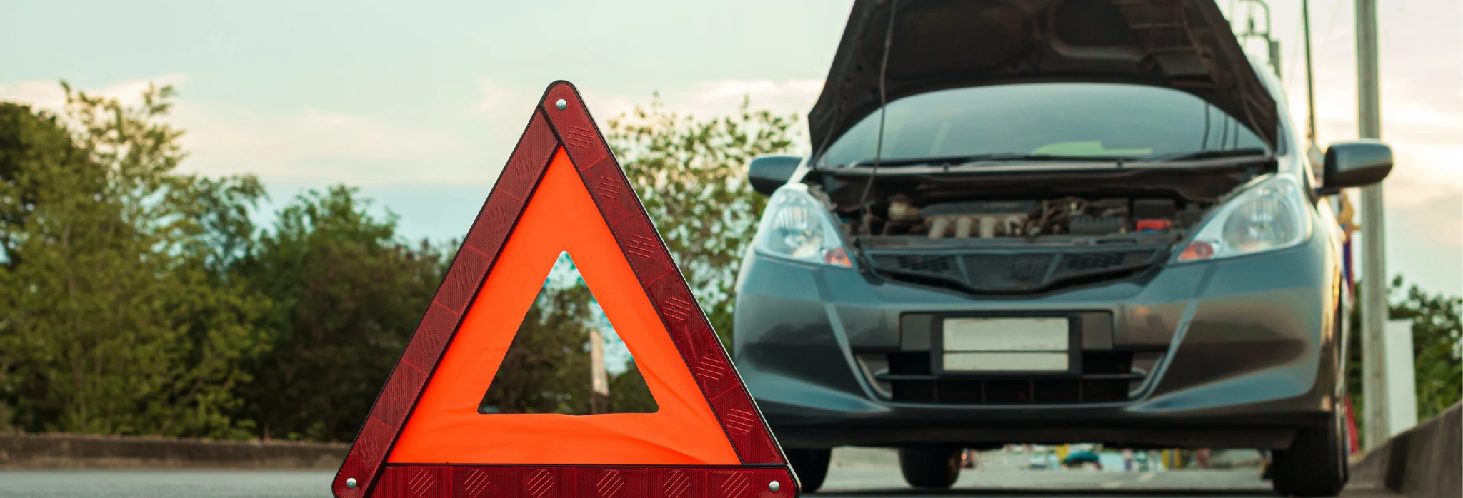 Σταματημένο αυτοκίνητο με βλάβη και προειδοποιητικό τρίγωνο.