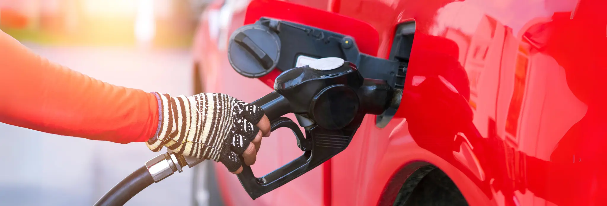 Χέρι  τοποθετεί αντλία βενζίνης σε αυτοκίνητο.