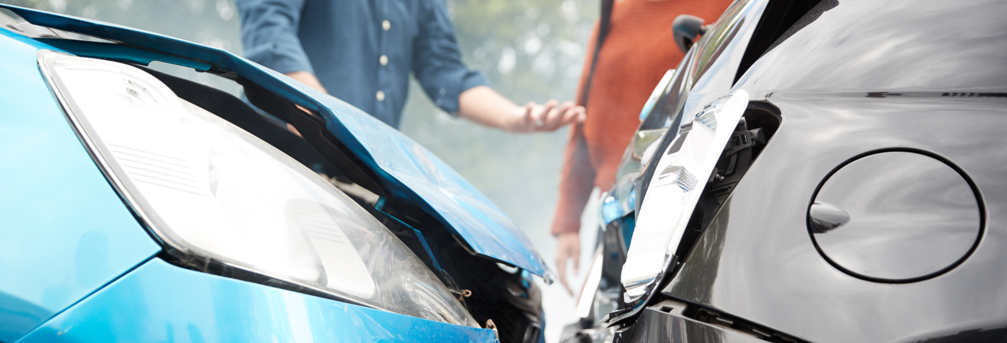 Δύο αυτοκίνητα έχουν συγκρουστεί και οι ιδοκτήτες στο βάθος συζητάνε για τη ζημιά.