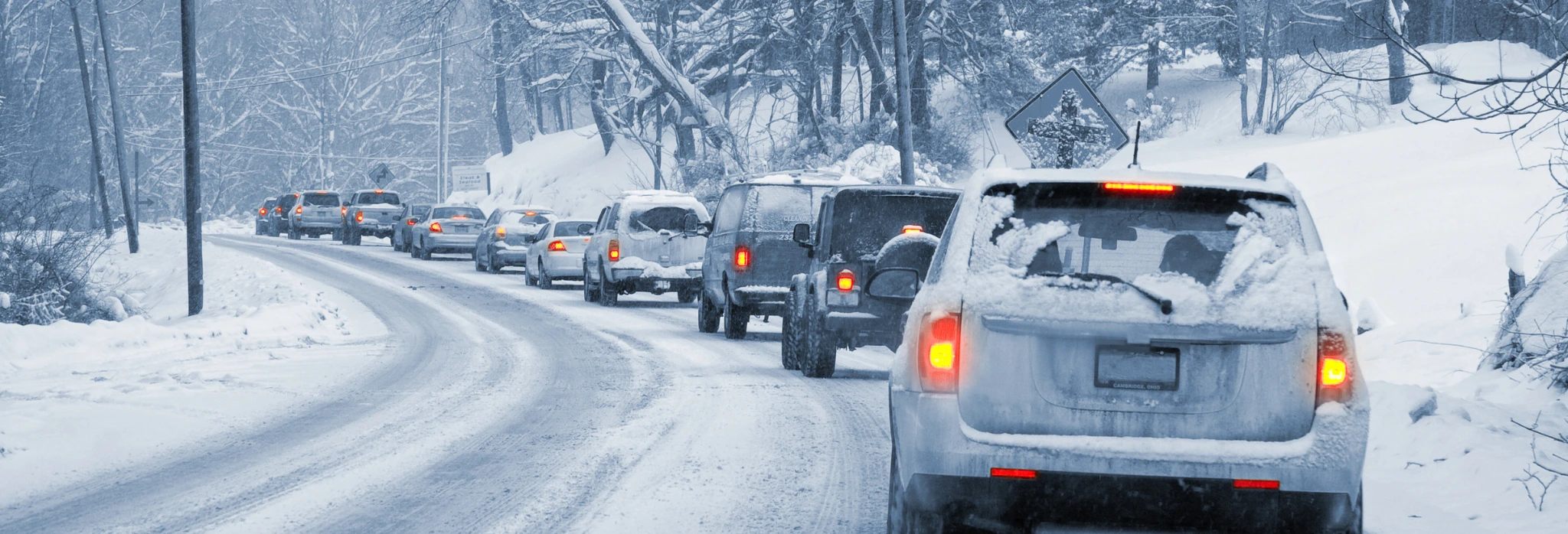 Αυτοκίητα οδηγούν σε χιονισμένο τοπίο.