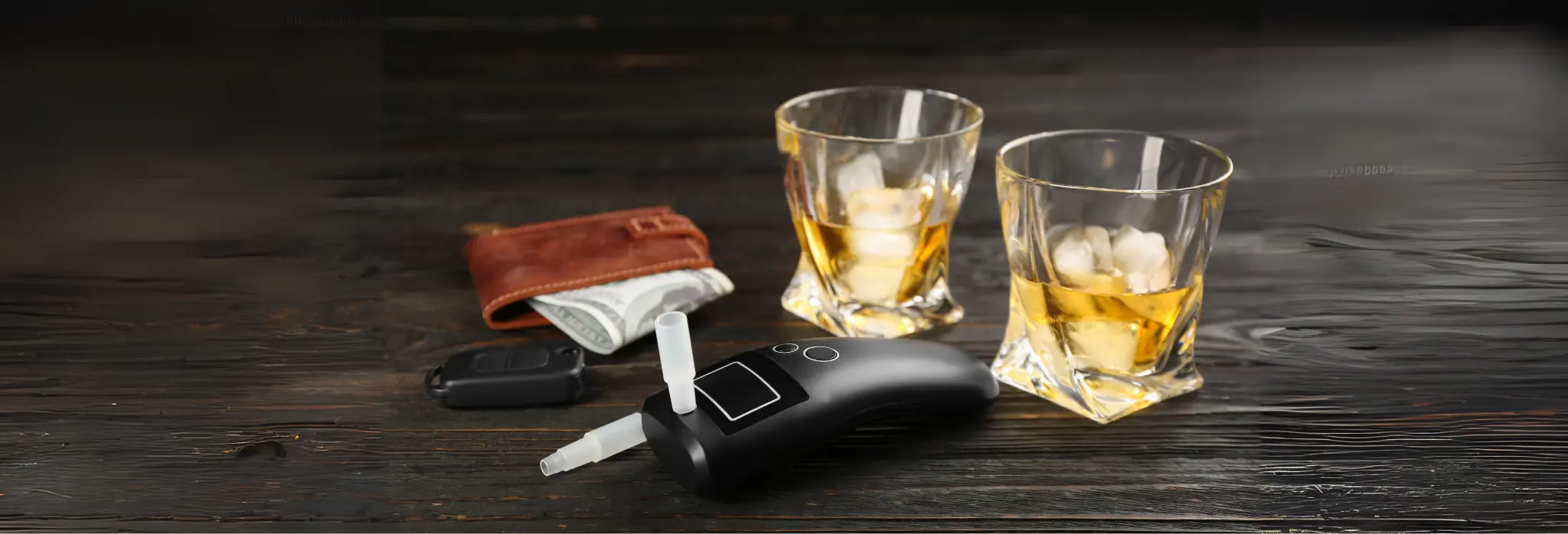 2 ποτήρια με ποτό με πάγο, ένα πορτοφόλι με χρήματα, κλειδιά αυτοκινήτου και αλκόμετρο.